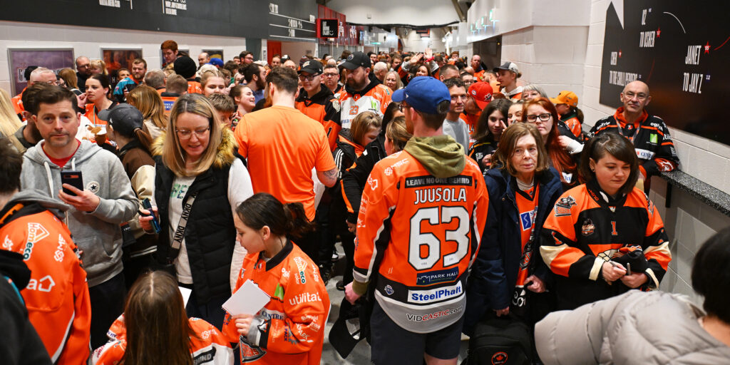 The image shows fans and ice hockey players meeting to enter a raffle