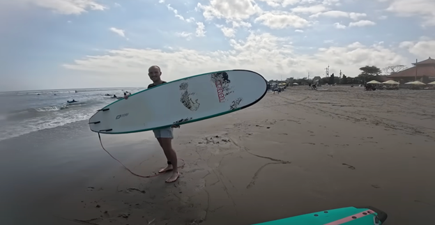 An image of Mashtag's raffle winner with a surf board in Bali